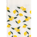 Détail motif citrons jaunes et verts sur chaussette femme mi-haute blanche.