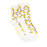 Paire de chaussettes femme moyennes blanches à motifs citrons jaunes et feuilles vertes, présentées à plat.