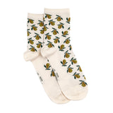 Paire de chaussettes femme courtes écrues à motifs poires vertes et dorées, présentées à plat.