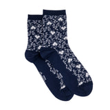 Paire de chaussettes femme moyennes bleu marine à motifs floraux blancs, présentées à plat.