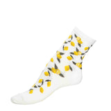 Chaussette femme moyenne blanche à motifs citrons jaunes et feuilles vertes, vue latérale.