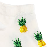 Détail de la maille blanche à motifs ananas jaunes, fantaisie.