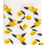 Détail du motif citrons jaunes et feuilles vertes sur chaussette femme blanche.
