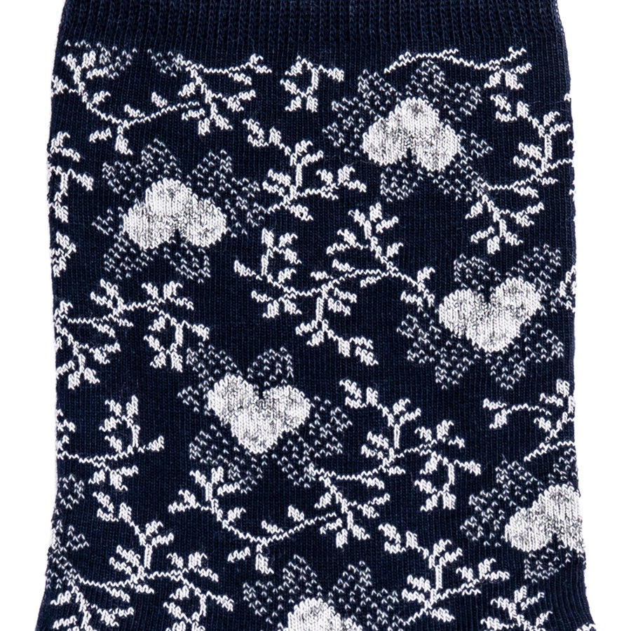 Détail du motif floral blanc sur chaussette femme moyenne bleu marine.