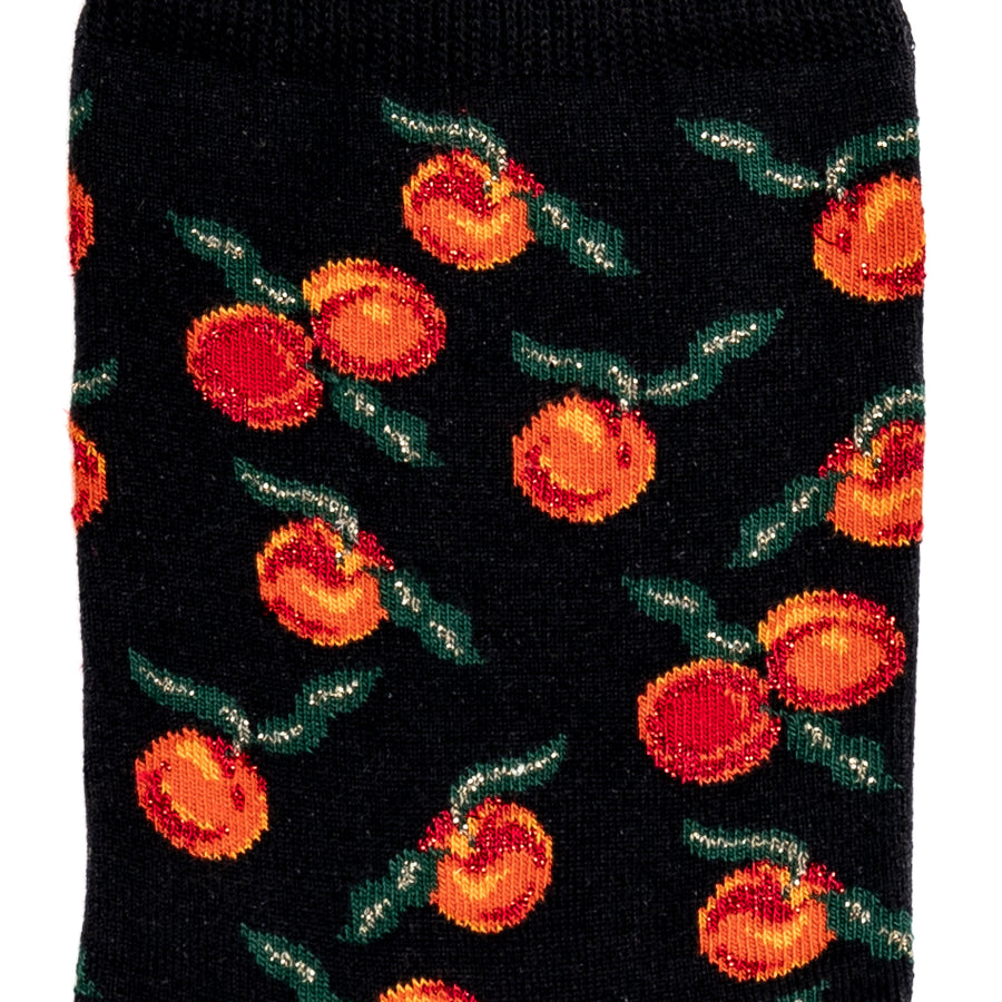 Détail du motif oranges et feuilles vertes sur chaussette femme noire.