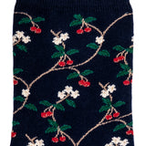 Détail motifs cerises rouges et fleurs blanches sur chaussette femme mi-haute bleu marine.