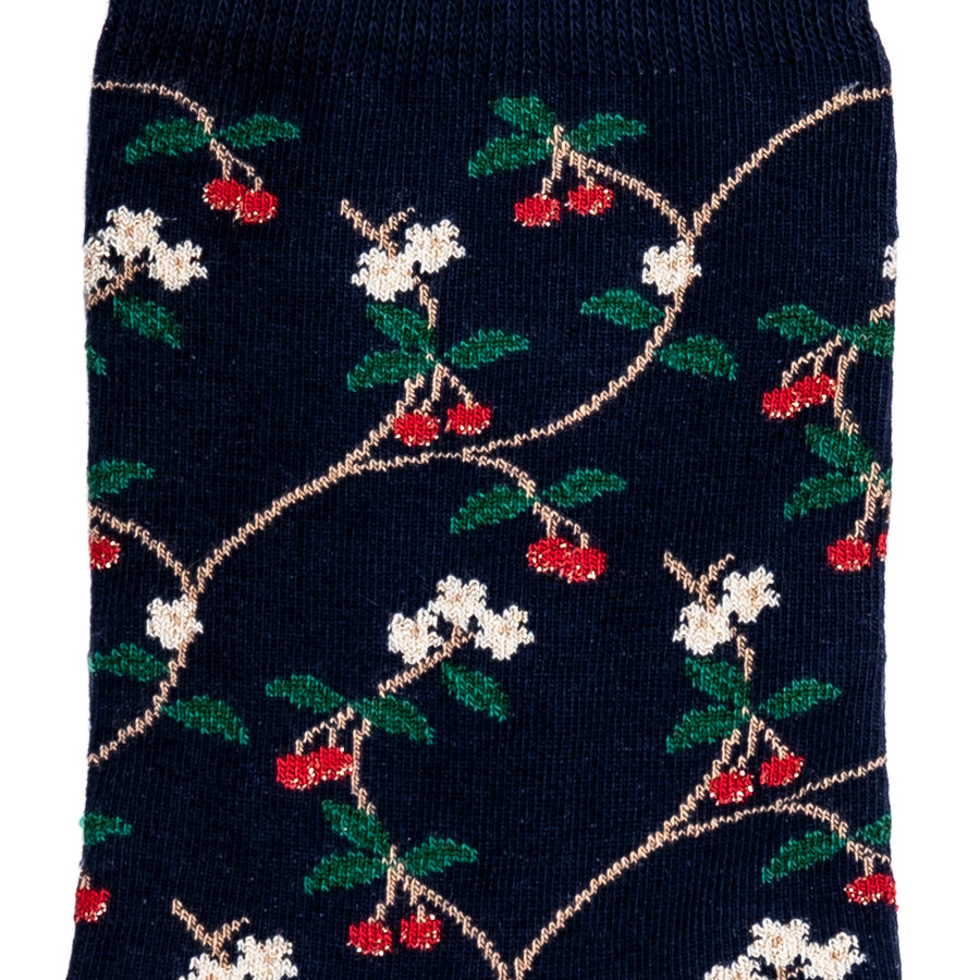 Détail motifs cerises rouges et fleurs blanches sur chaussette femme mi-haute bleu marine.