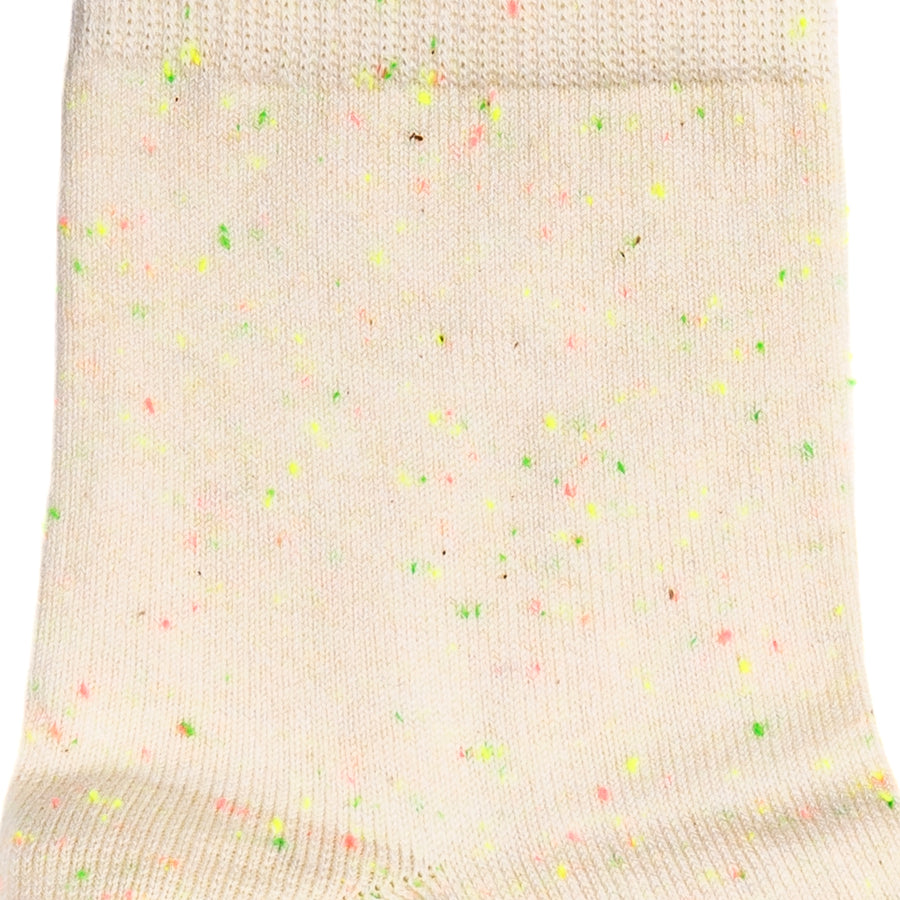 Détail maille écrue avec touches multicolores, style fantaisie.